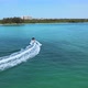 Following a boat in the ocean pulling people on an inflatable tube. The camera orbits around speedbo - VideoHive Item for Sale
