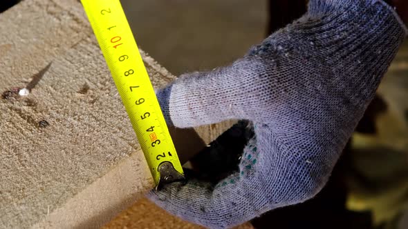 Measuring yellow tape measure scale with centimeters on wooden boards for marking the place of cutti alt