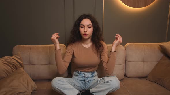 Woman Sitting on Couch Lotus Pose Put Hands on Lap Folded Fingers Closed Eyes Enjoy Meditation Do alt