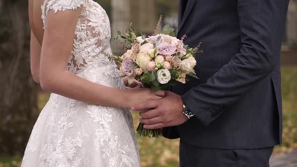 Wedding Walk, Close-up of a Bride and Groom Holding Hands alt