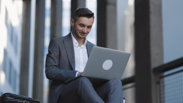 Bearded Man Working With Laptop Computer Outside the Office  alt