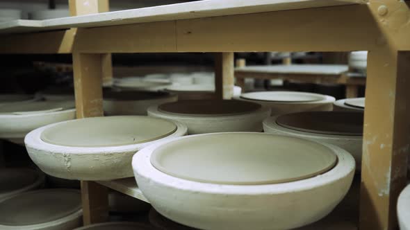 Molds for Ceramic Dishes are on the Shelves of Production and Ceramics Harden in Them alt