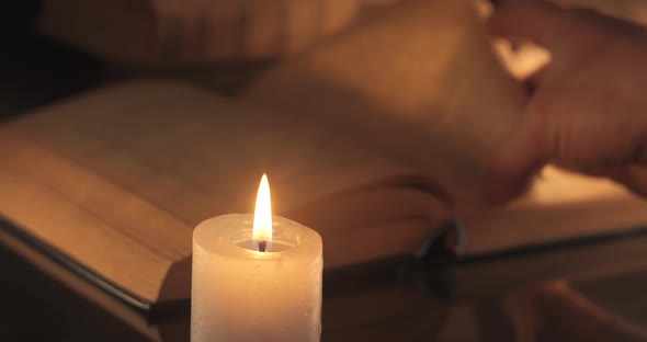 A Man Reads and Turns Over the Yellow Pages of an Old Book alt