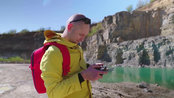 Drone Pilot Is Looking for a Quadcopter in the Sky. Young Man Controls a Drone Using a Remote