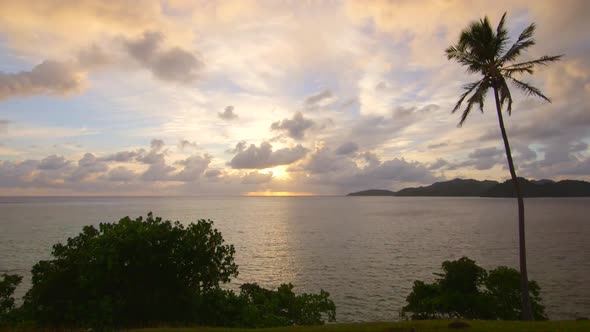 View of a scenic tropical island in Fiji at sunset. alt