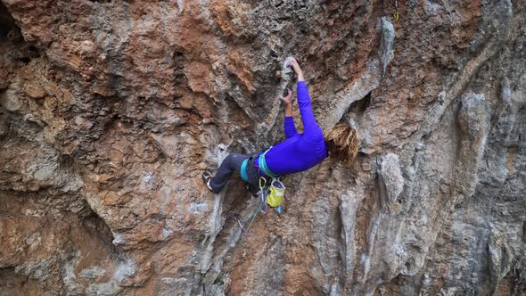 Cinematic Slow Motion Footage of Strong Female Climber Climbing Very Hard Overhang Route Making Hard alt