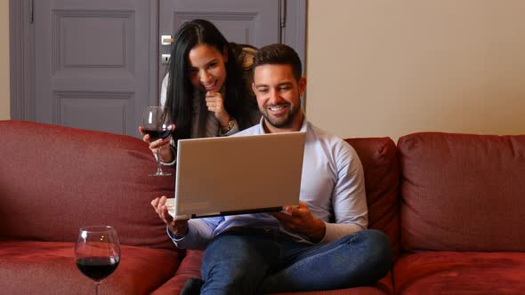 A young couple using a laptop together in the living room
