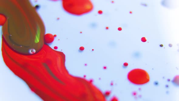 Close Up of a Large Drops of Red Paint Fall in Oil alt