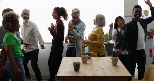 Dancing multiracial people having fun together at home kitchen