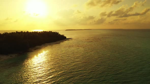 Aerial drone shot scenery of tranquil seashore beach vacation by blue ocean with white sand backgrou alt