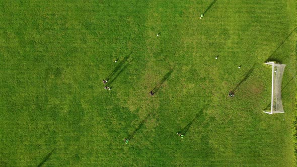 Aerial drone view of a sports field and a football team that practices tactical schemes