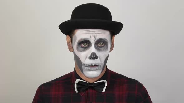 A Horrible Man in Clown Makeup Sneezes Heavily. The Scary Clown Looks at the Camera and Sneezes alt