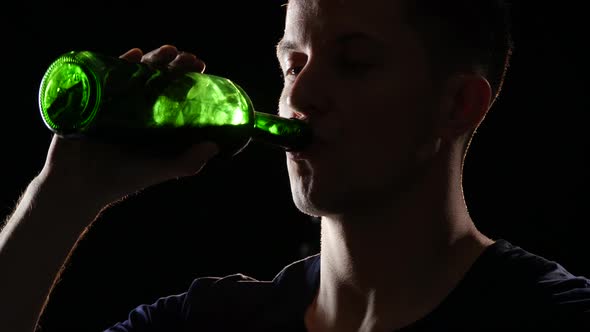Drinking Wine From the Bottle. Back Light. Close Up alt