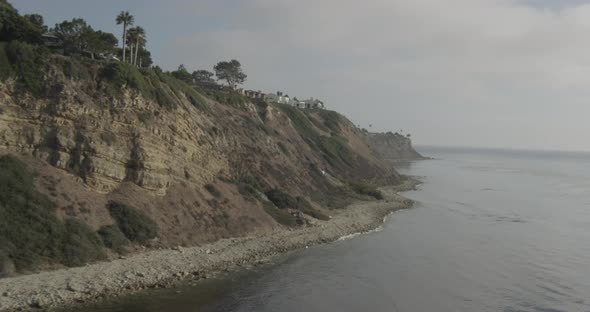 Helicopter aerial shot of sunsetting by cliffside ocean view