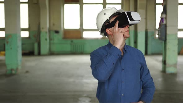 A Modern Engineer Wearing Virtual Reality Glasses Inspects a Construction Site
