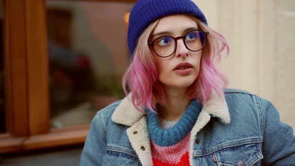 Pensive woman in hat looking at the top and drawing in cafe alt