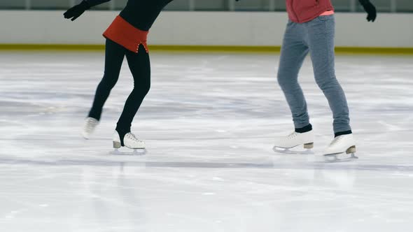 Figure skating coach teaching girl to do step sequence