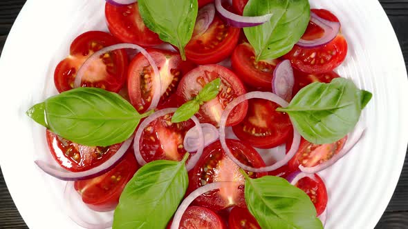 Tomato Salad with Basil and Chopped Onion in White Ceramic Dish Rotate Slowly