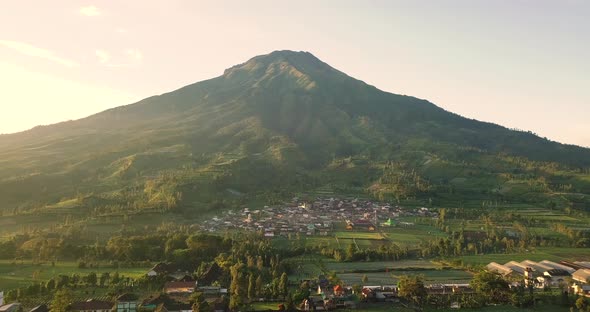 Mount sumbing with rural view and lush trees in tobacco plantations with blue sky on the background alt