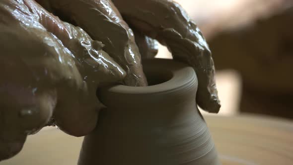Dirty Hands of Potter Making Pot Close Up alt