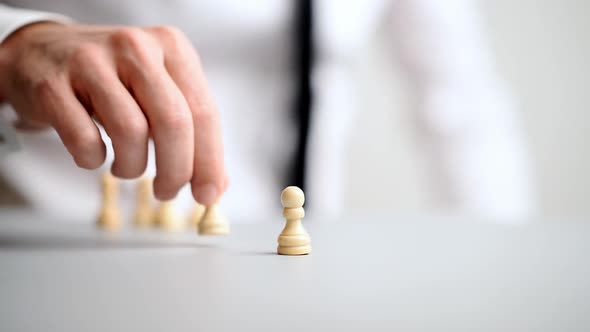 Businessman Placing Pawn Chess Figures On White Table