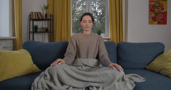 Front View of Young Woman Meditating Alone at Home on Apartment Background. Attractive Girl with alt