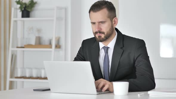 Pensive Businessman Thinking and Working on Laptop alt
