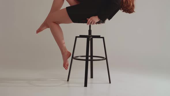 Model in a Dress on a Chair in a Photo Studio