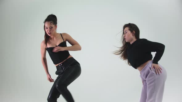 Two Young Stylish Women Models Dancing on Cyclorama alt