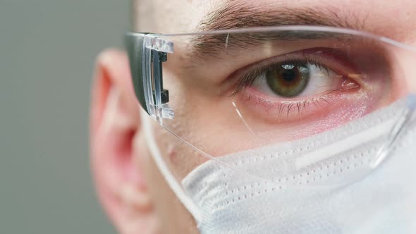 Closeup of Doctor Scientist Specialist Wearing Medical Protective Glasses and Mask Halfface Portrait alt