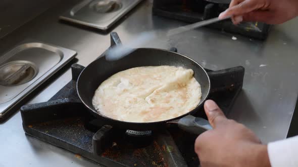 Cook Prepares an Omelet on Frying Pan Closeup