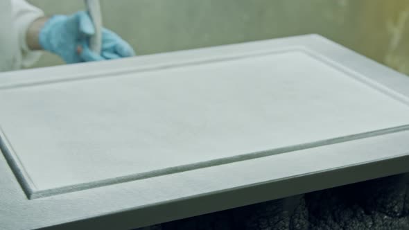 Slow motion of a worker painting kitchen wood doors using spray paint alt