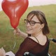 Disabled Caucasian Young Woman with Red Balloon Looking Over the Shoulder and Smiling  - VideoHive Item for Sale