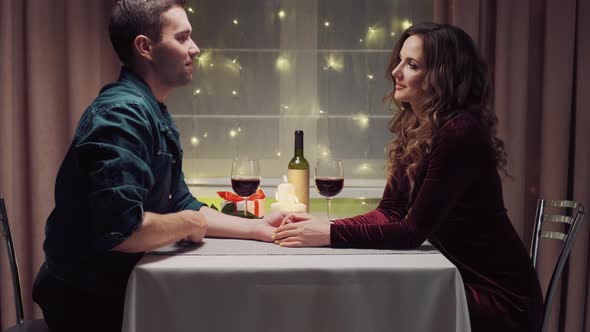 Two People in Love Communicate During Dinner and Drink Red Wine in Glasses