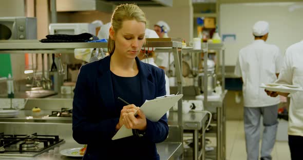 Female manager and male chefs interacting with each other 4k alt