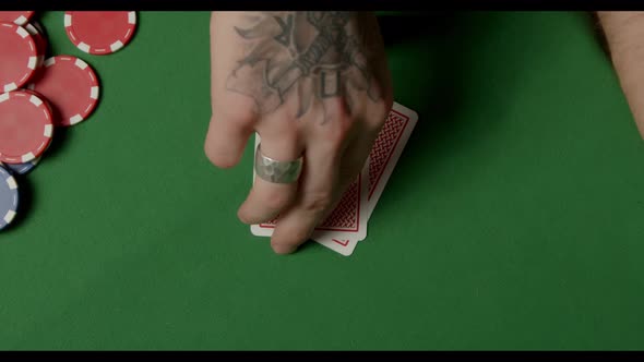 A Man with a Tattoo Throwing Double Aces on Poker Chips. Showdown a Pair 