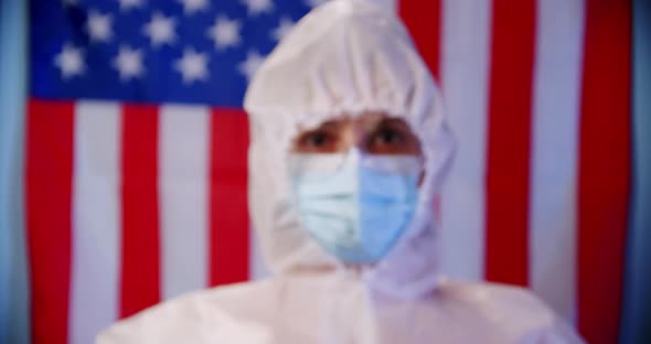 Blured Doctor or Nurse Wearing Personal Protective Equipment and Holding Syringe of Corona Covid19 alt