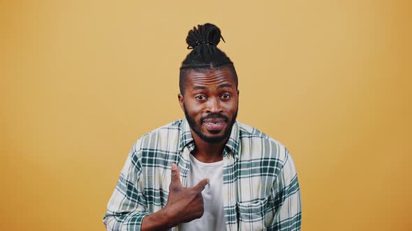 Young Dark Skinned Afro Guy Smiling Hitting Palm with His Fist Acting Like He Will Hit you alt