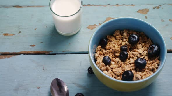 Muesli and blueberries in bowl with glass of milk 4k alt