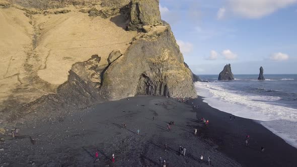 Aerial view of black beach with big waves and cliffs in Vik, Iceland