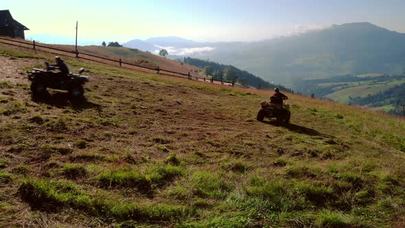 Three Friends Riding Quad Bikes on Mountain Hill in Summer alt