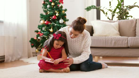 Mother and Daughter with Notebook at Christmas alt