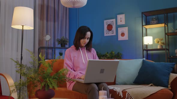 Confident Girl Freelancer Sit on Sofa Opening Laptop Notebook Screen Studying Working Online at Home alt