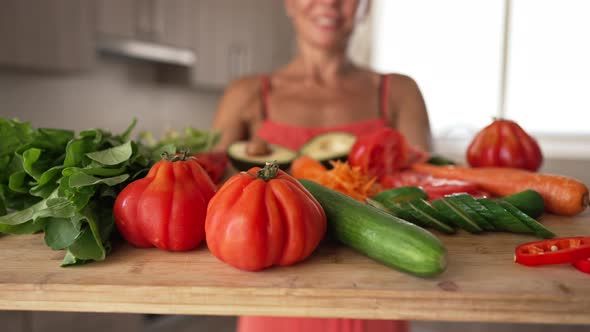 Closeup Healthful Organic Vegetables on Wooden Cutting Board with Blurred Unrecognizable Caucasian alt