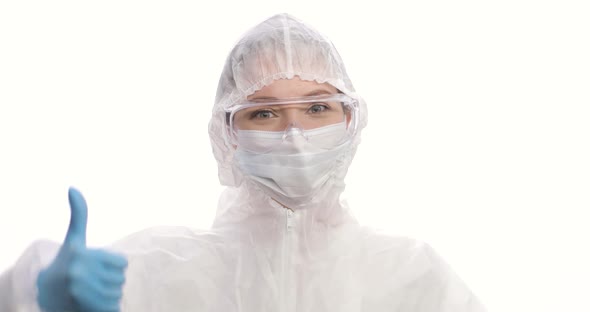 Portrait of Woman in a Protective Suit Mask Gloves and Glasses Smiling Thumbs Up