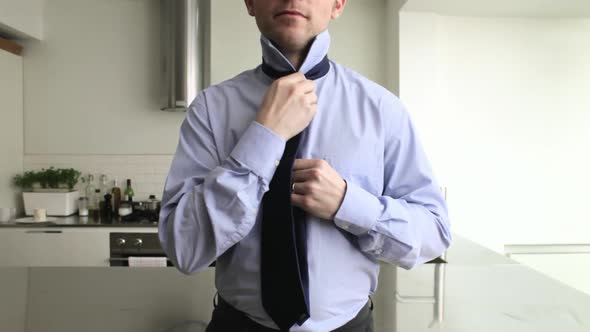 Businessman tying tie alt
