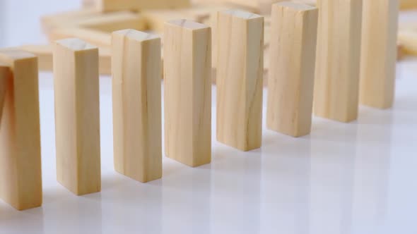 Domino Effect Row of Wooden Domino Falling Down on White Background alt