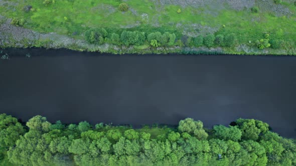 Top View of the River Surrounded By Trees and Meadows alt