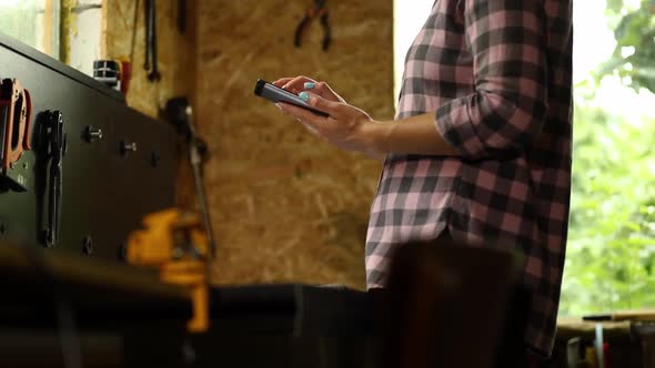 Female business owner using digital tablet in workshop