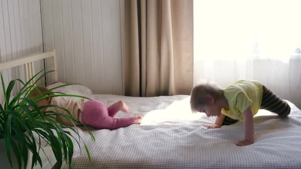 Two Happy Cheerful Little Children Brother and Sister Play Have Fun Jump on Bed alt
